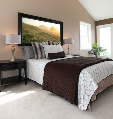 a carpet room
               with a high sloping ceiling, two smakk bright windows, and a two-person
               bed with a vedside table and lamp on each side